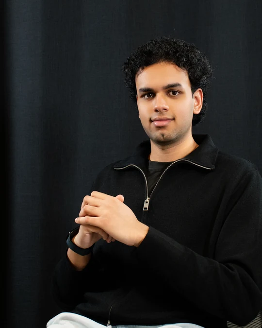 Portrait in a black top against a dark backdrop