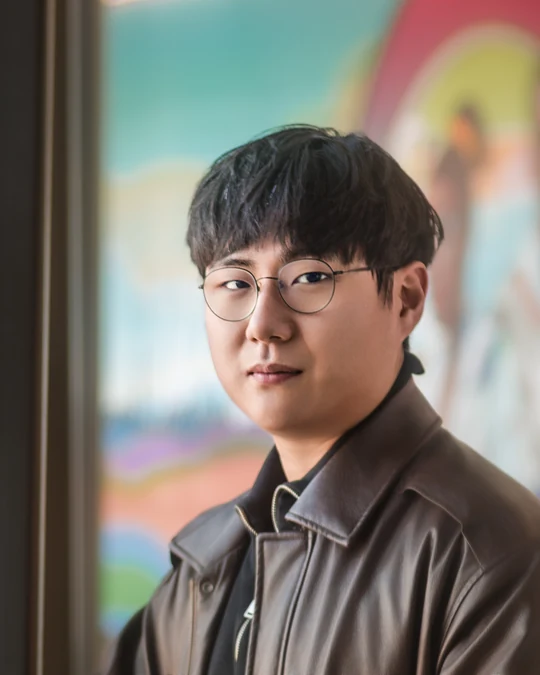 Close portrait of a man with glasses in a brown jacket