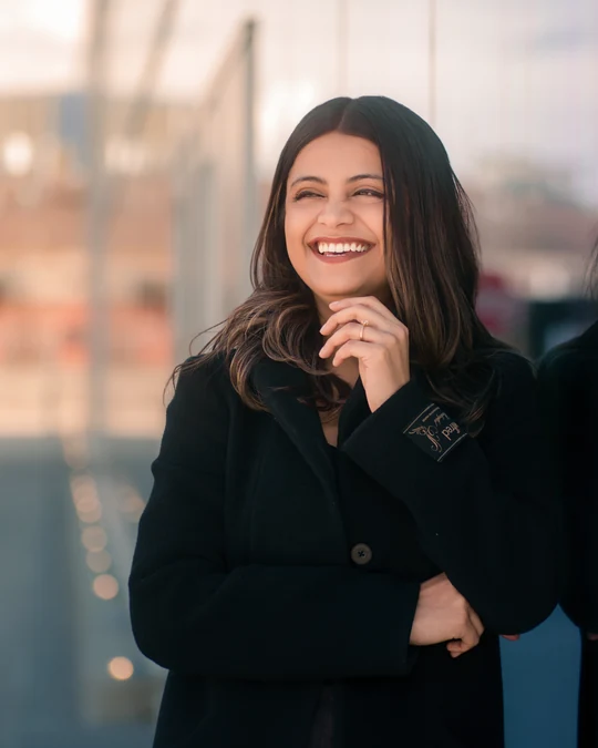 Smiling portrait in a black blazer with a softly blurred background