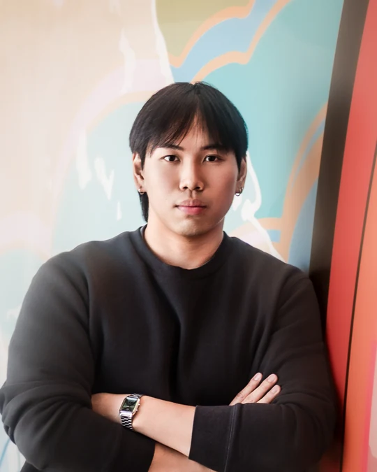 Portrait in a black top with a colourful background